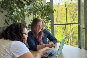 Calley Stevens Taylor works with a student on their laptop.